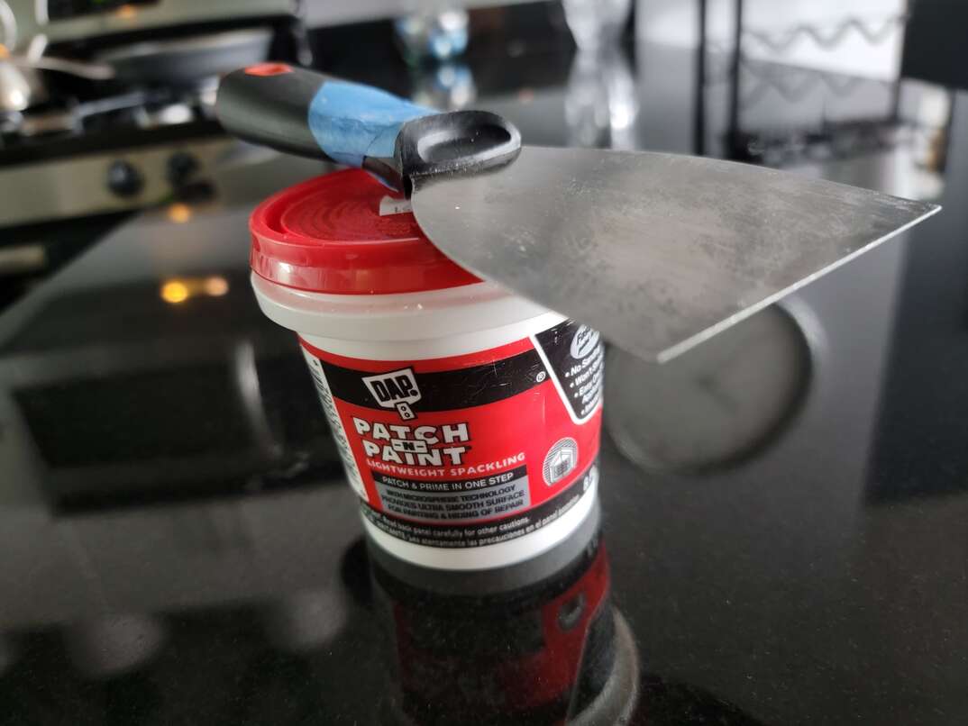 Spackle and sparkle tool sitting on a dark countertop