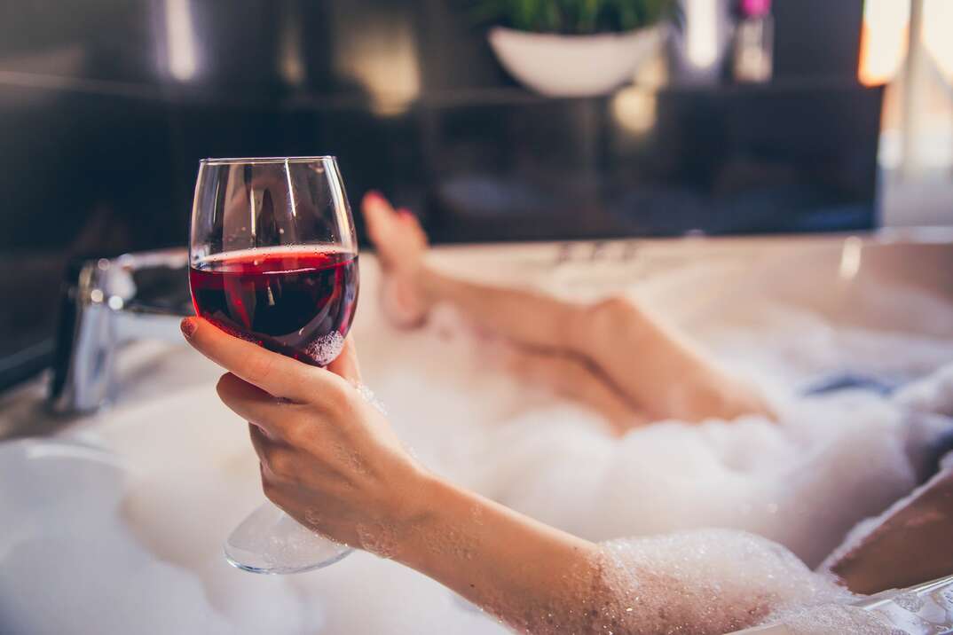 Woman Hand Holding Wineglass In Bathtub