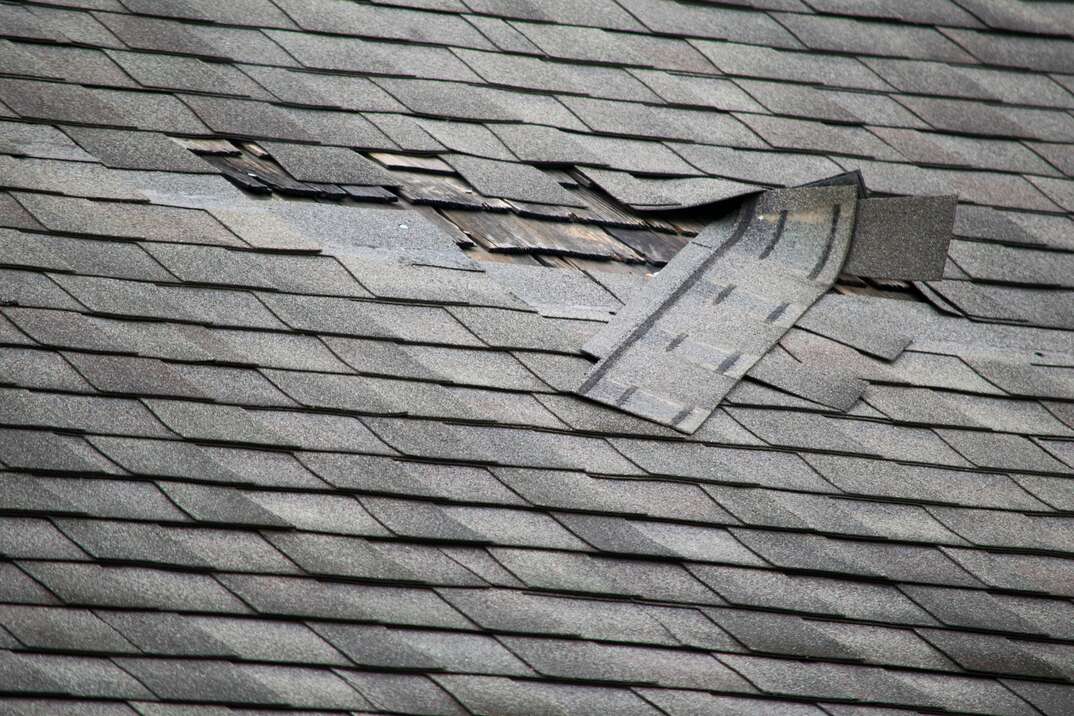 Residential roof with damage to several shingles