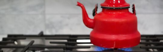 red teapot on gas stove