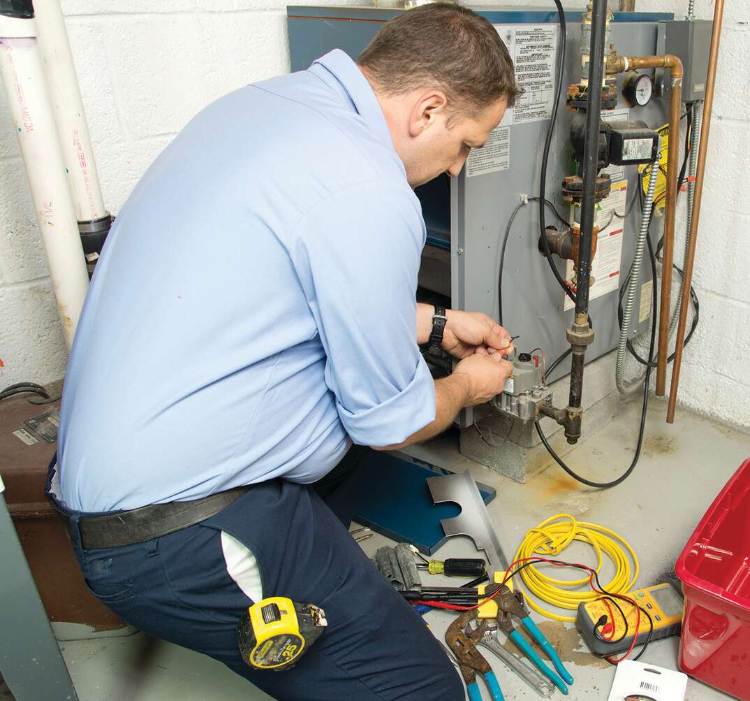 technician fixing furnace