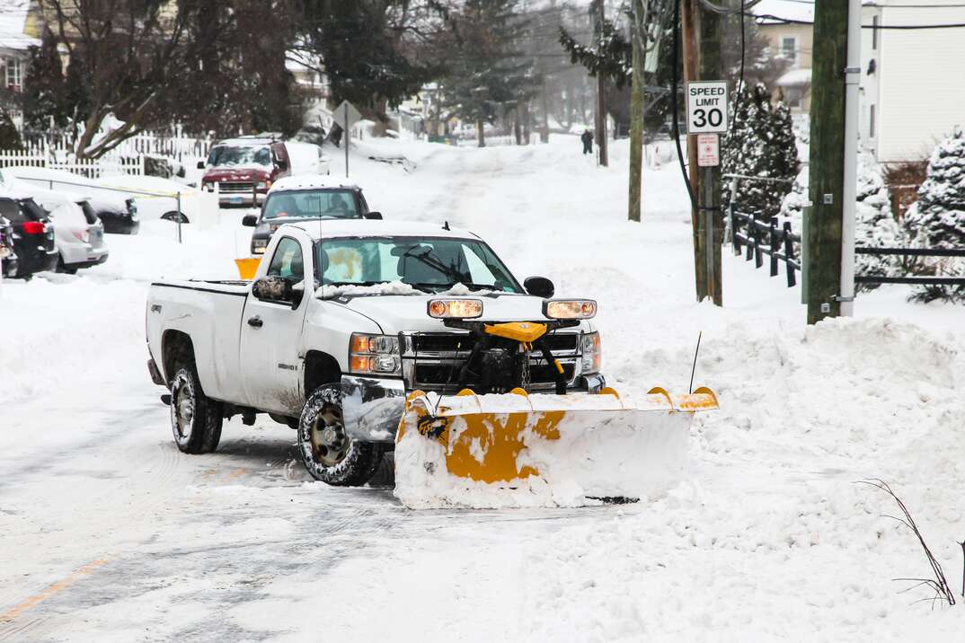 NORWALK, CT, USA-DECEMBER 17, 2020: Snow plowing truck on Taylor Avenue after winter snow storm.