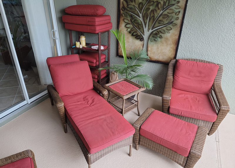outdoor patio furniture, patio furniture, patio, screened-in porch, screened porch, red furniture, red cushions, cushions, red, brown, sliding glass door, glass door, window, glass, painting, painting of tree, wall art, stacked cushions