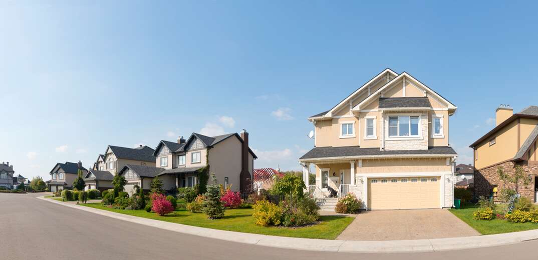 Long row of upscale "empty-nester" type brick and stone faced luxury town homes.Several absolutely new suburban houses in sunny summer afternoon.