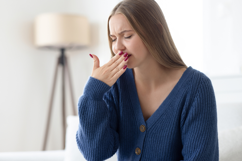Sick woman covering her mouth