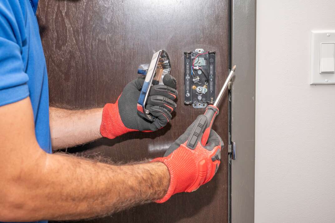 Hands working on a door lock