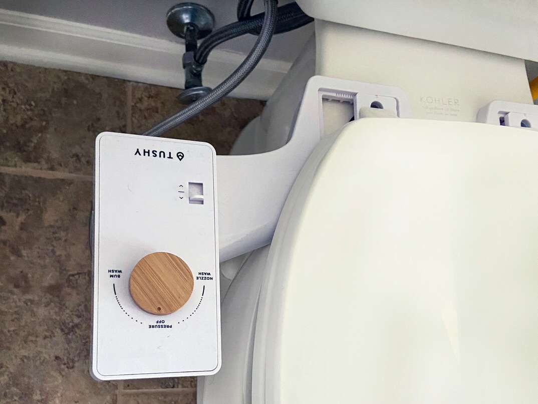 top down view of a residential toilet with an aftermarket  bolt-on  bidet