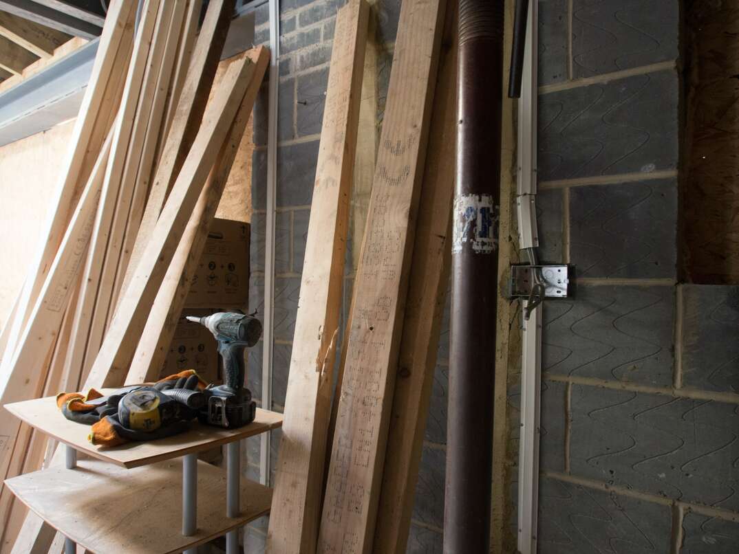 stack of lumber leaning against a wall