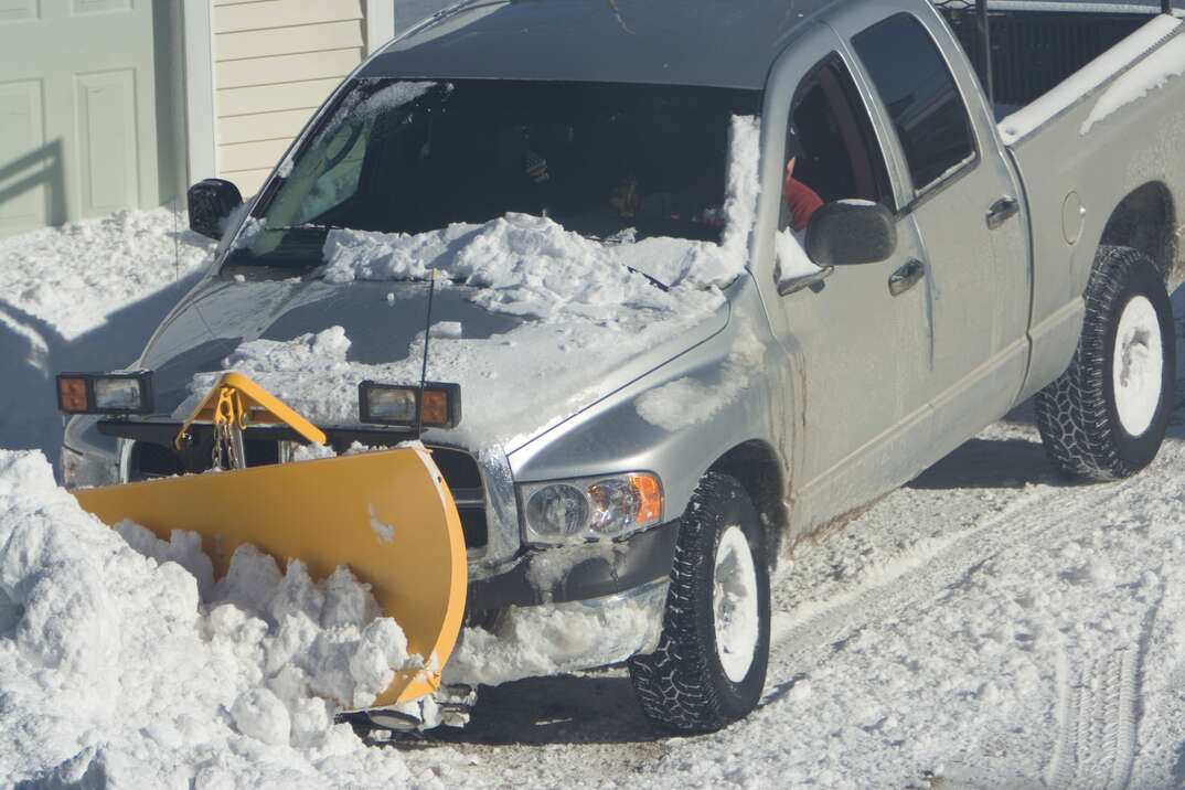 Pickup truck plowing snow in front of house