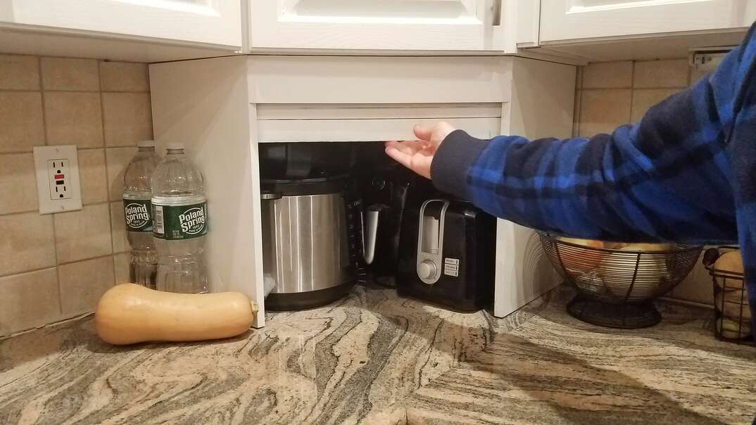 Countertop corner appliance garage installed between cabinets and countertop