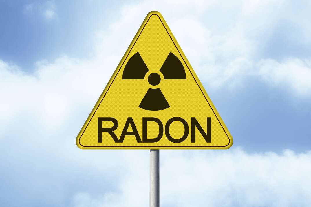 Danger of radioactive contamination from RADON GAS - concept with warning symbol of radioactivity on road sign - image with copy space