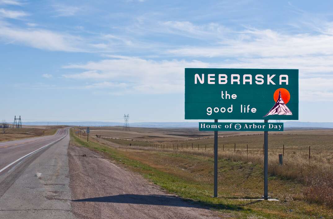 Welcome to Nebraska sign alongside a quiet highway 