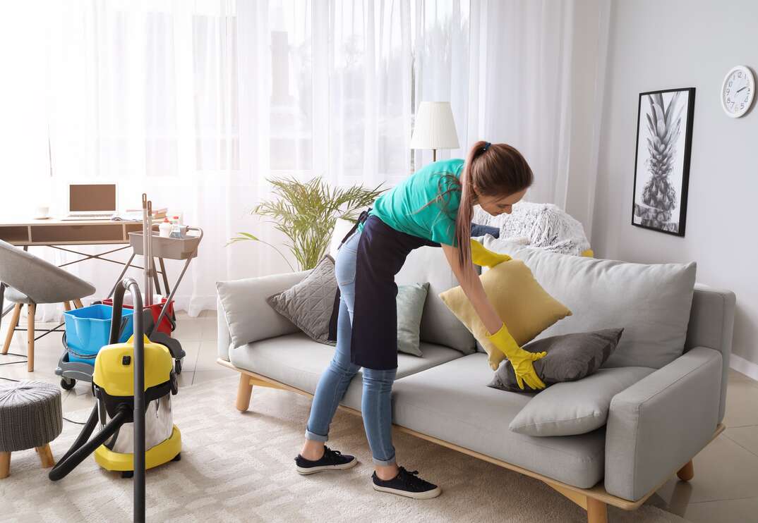 Female janitor cleaning room