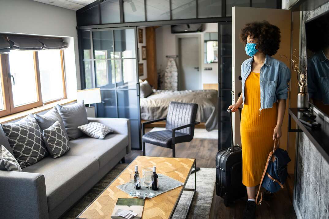 Woman arriving to vacation rental with suitcase