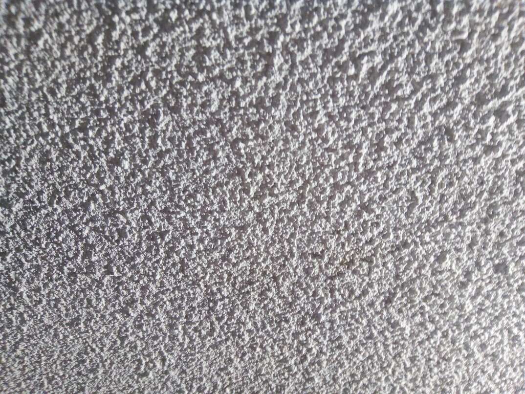 A closeup image of a popcorn ceiling shows the detailed texture of this antiquated style, popcorn ceiling, popcorn, ceiling, residential, house, home