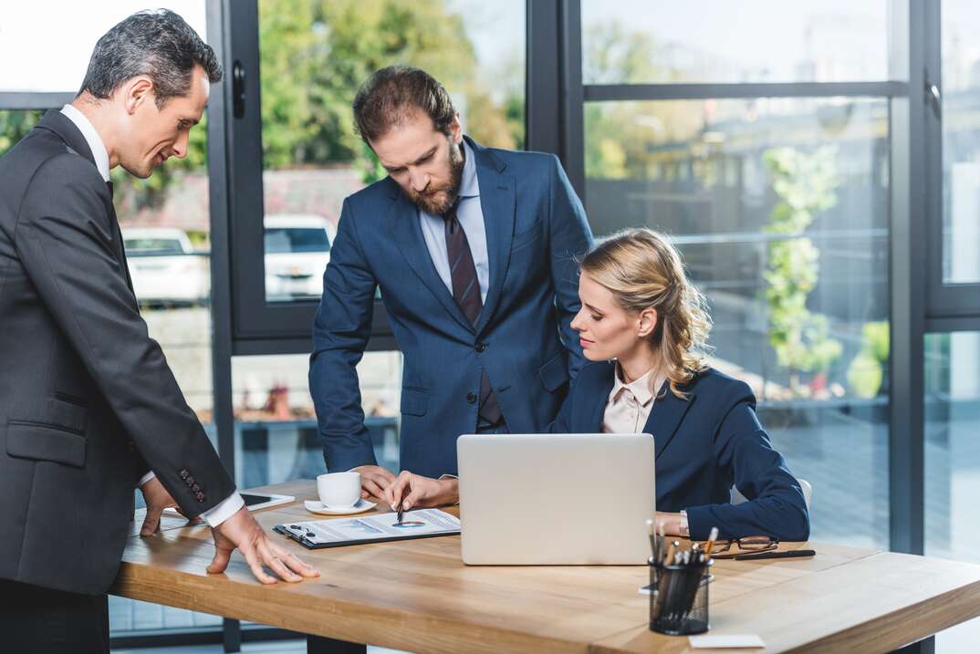 portrait of group of lawyers discussing work together at workplace with laptop in office