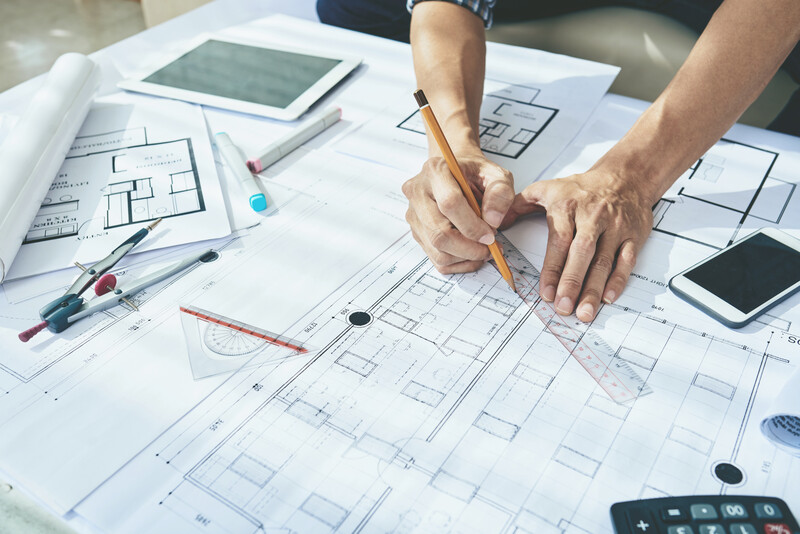 Close-up image of engineer drawing blueprint of building