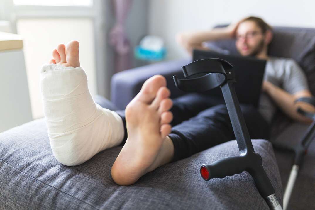 Boy with crutches and broken leg at home