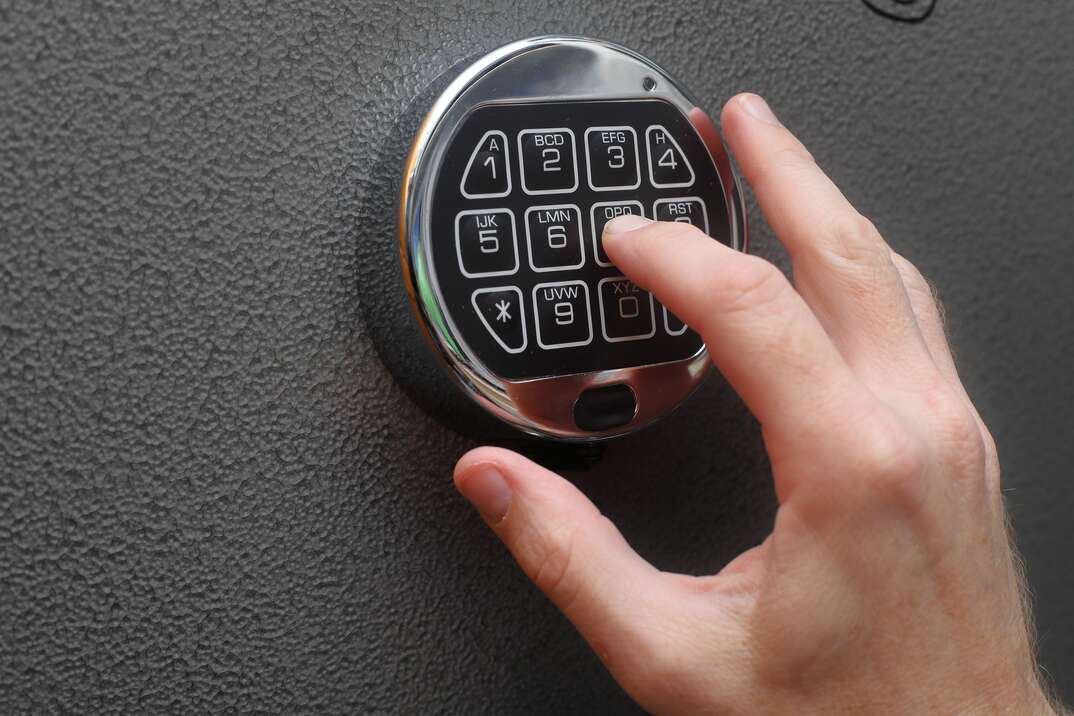 person punching in a code on a safe lock
