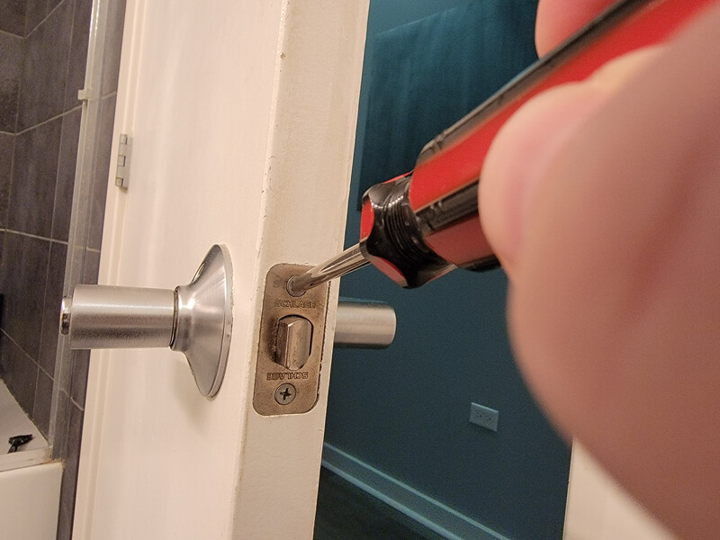 removing a doorknob with a screwdriver