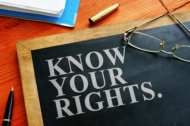 A sign or chalkboard lying on a desk with eyeglasses on top of it reads Know Your Rights, Know Your Rights, rights, employment, unemployment, fired, terminated, wrongful termination, pen, ink pen, chalkboard, sign, legal issue, legal, legal aid, legal assistance