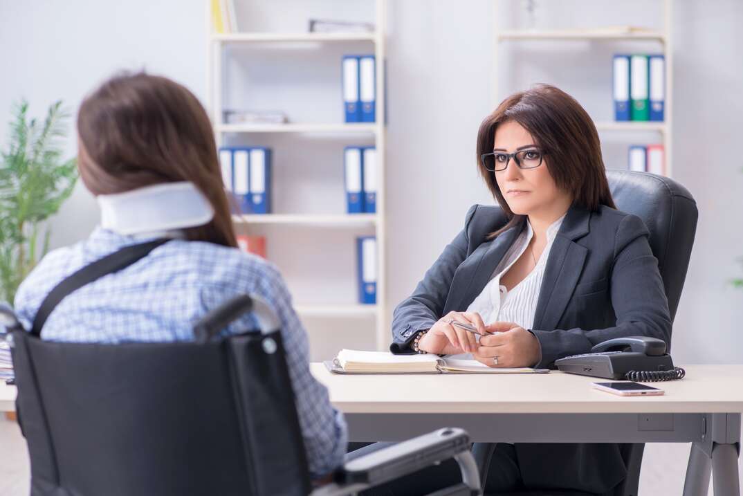 injured female employee visiting lawyer for advice on insurance