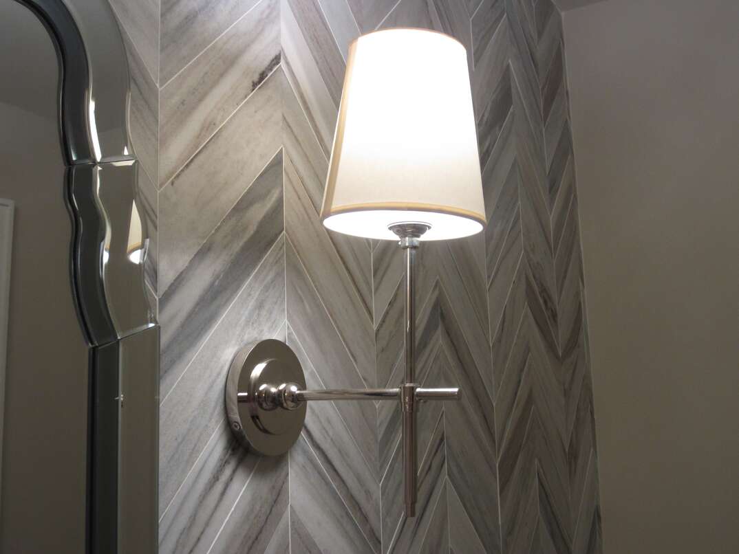 Mounted sconce on a tile wall in the bathroom