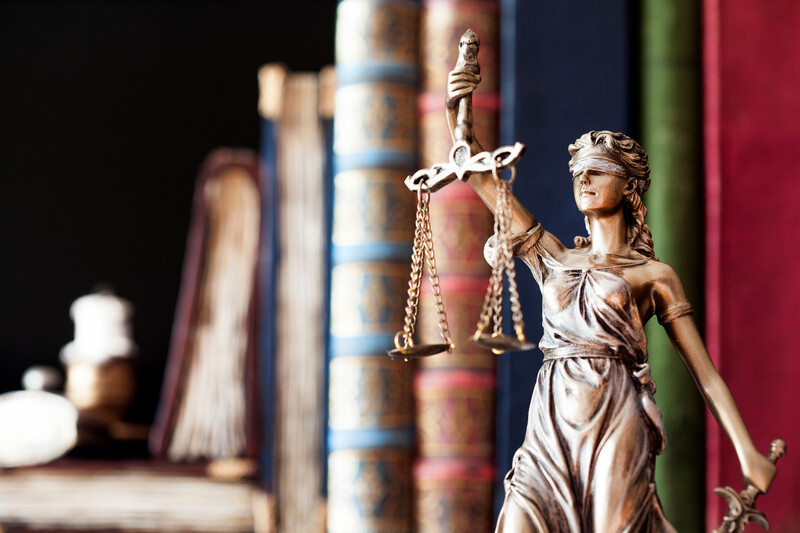 statue of justice on bookshelf in law office