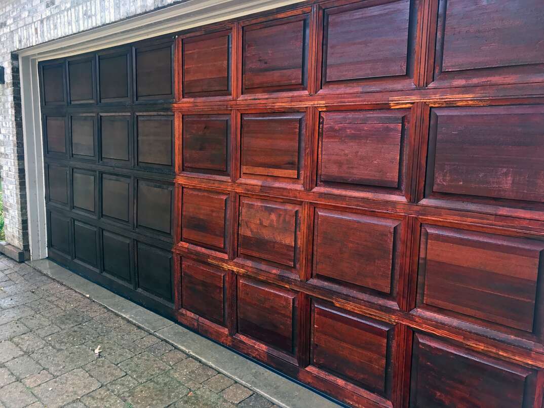 Aged red oak garage door getting power washed and refinished.