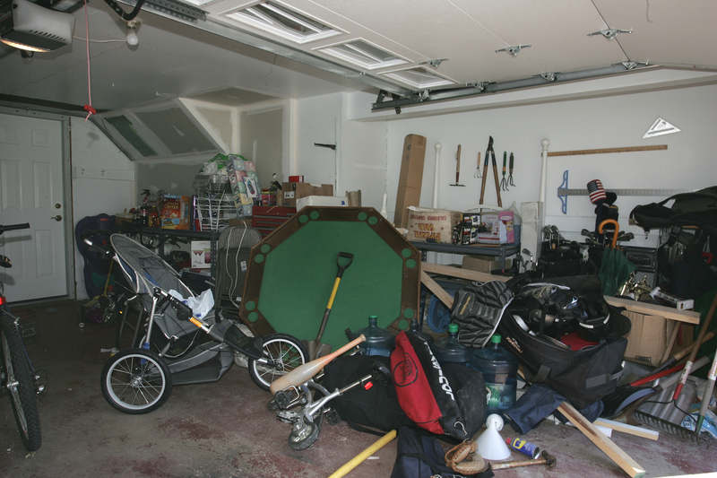 Suburban garage mess.  Boxes, tools and toys in disarray.